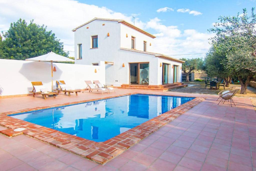 a villa with a swimming pool in front of a house at Finca Les Oliveres in Benissa