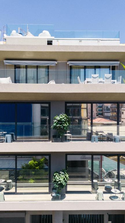a building with two potted plants on the balcony at Silk Athens Urban Collection in Athens