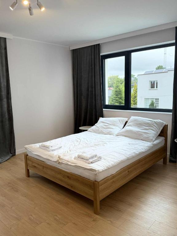 a bed in a bedroom with a large window at Apartamenty Sokół in Drohiczyn