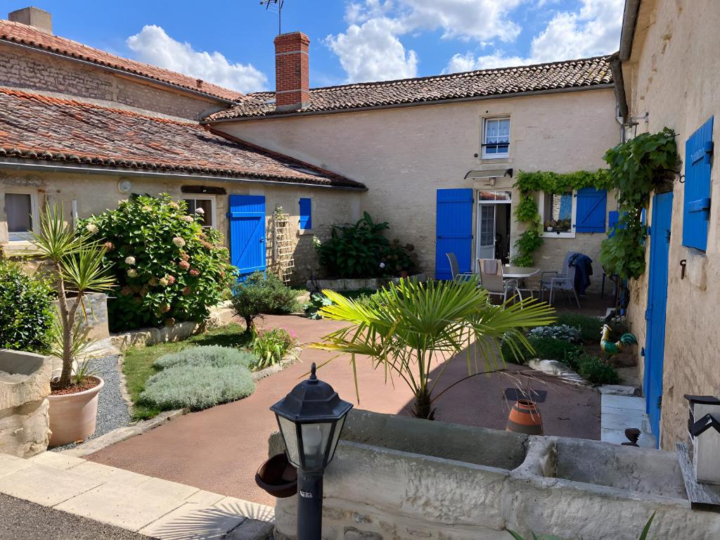 a house with blue doors and a street light at Chez Jacques in Saint-Martin-de-Fraigneau