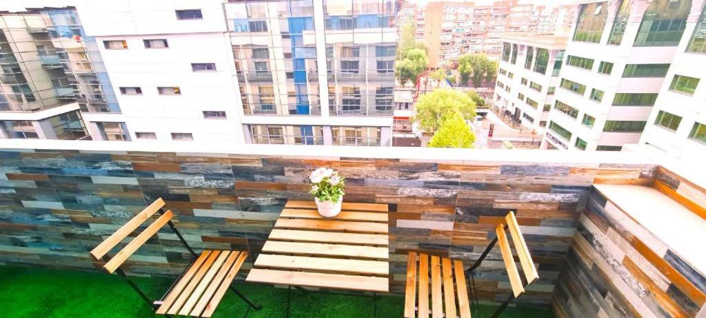 a balcony with two benches and a table with a plant at Oshun Madrid Norte LOFTS & MIDSTAY in Madrid