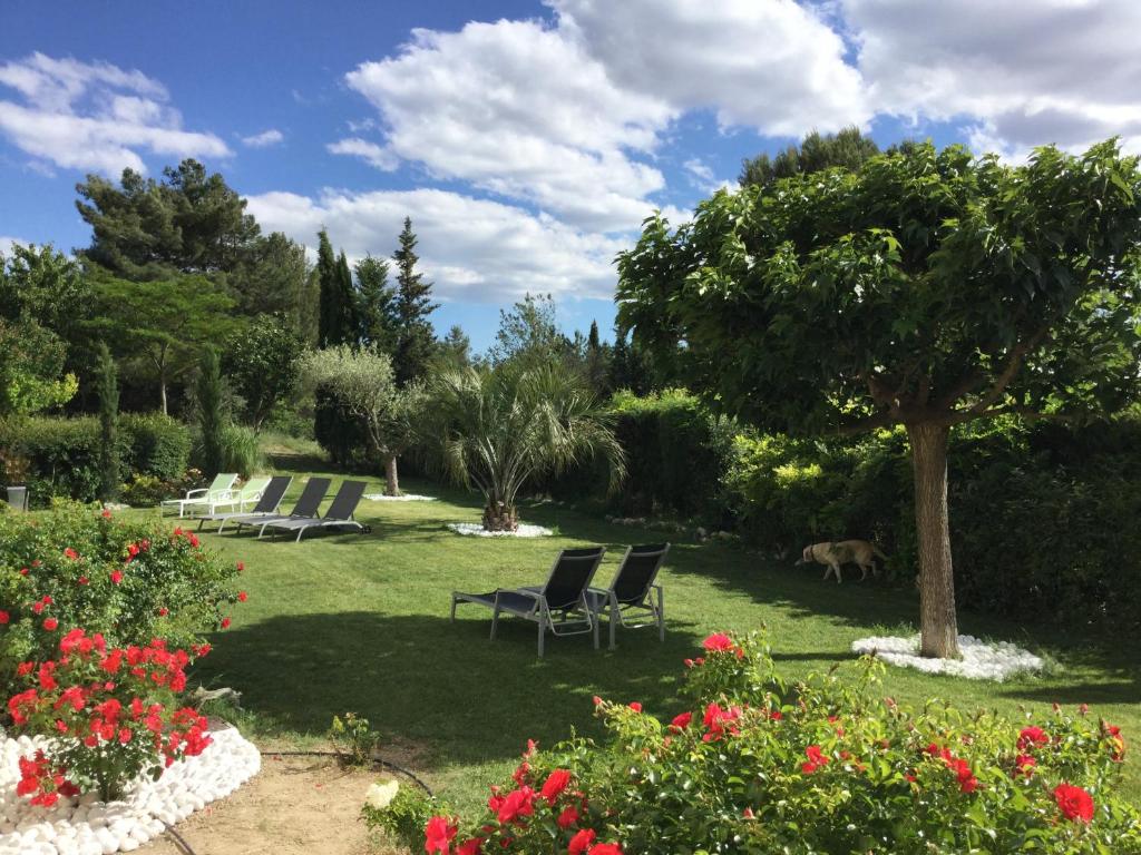 een tuin met stoelen en bloemen op een gazon bij Les 7 Roses d'Aix in Aix-en-Provence