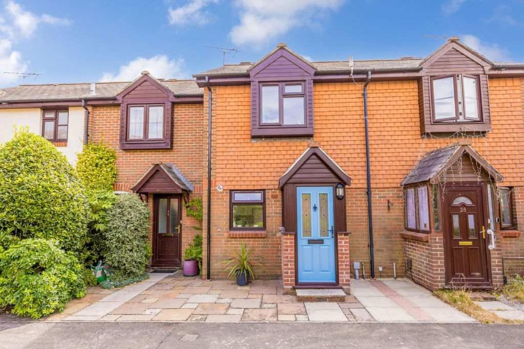 an orange brick house with a blue door at Sea Cloud - 2-bedroom House with Courtyard Garden in Poole