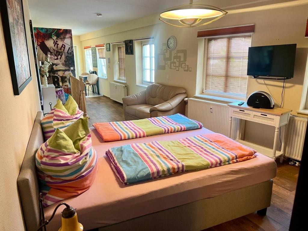 a bedroom with two beds and a living room at Ferienwohnung Stadtzauber in Malchow