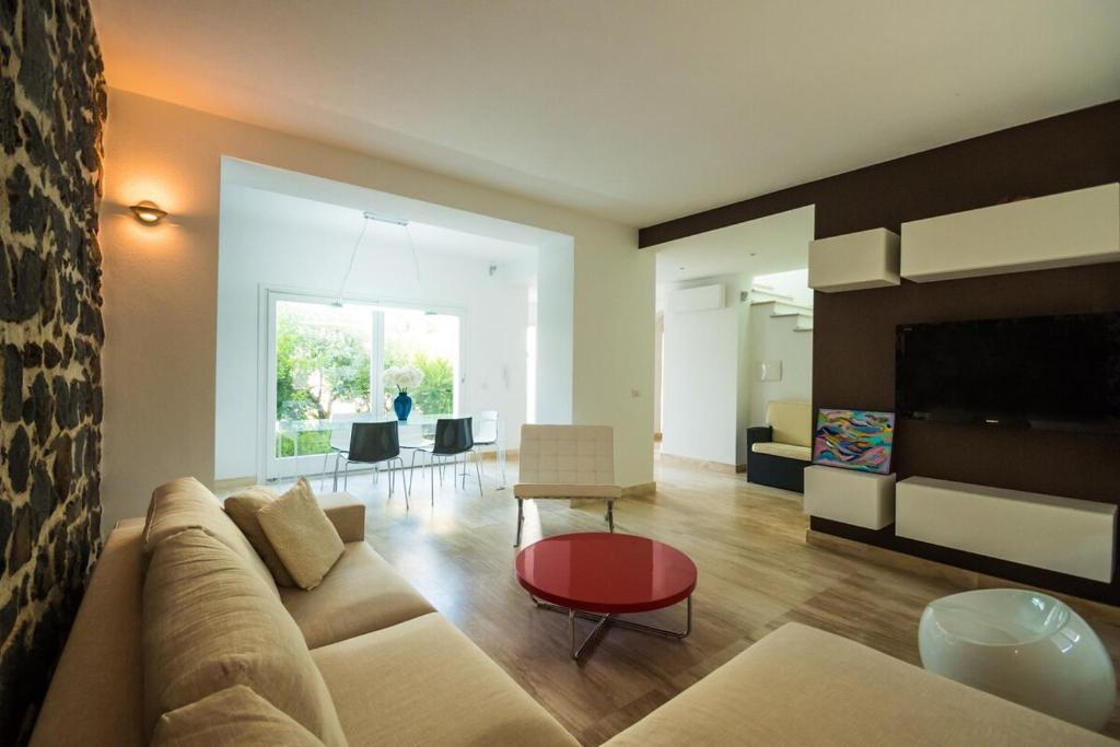 a living room with a couch and a table at Villa Ginevra- Private Pool in Orosei