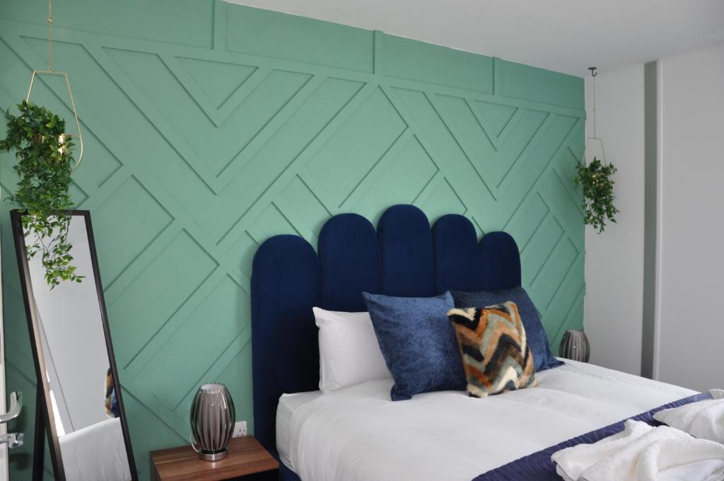 a bedroom with a blue and green wall at Modern 2-Bed Apartment, The Hub MK, Free Parking & Smart TV in Milton Keynes