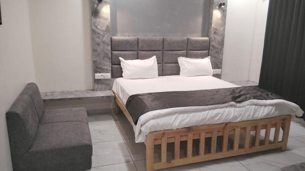 a bedroom with a large bed and a couch at Hotel riseinn in Jāmb