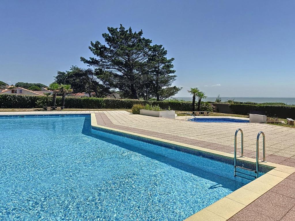 a swimming pool with blue water in a yard at Holiday Home Plein Océan-4 by Interhome in Pornic