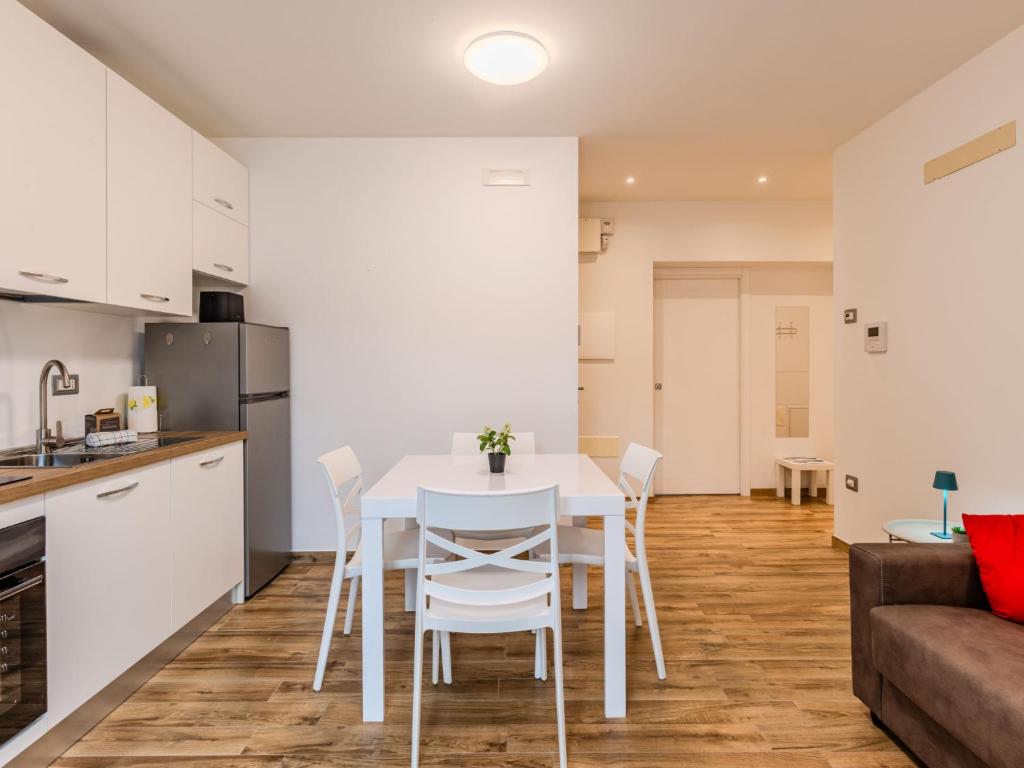 uma cozinha e sala de jantar com uma mesa e cadeiras brancas em Apartment Nespolo by Interhome em Dro