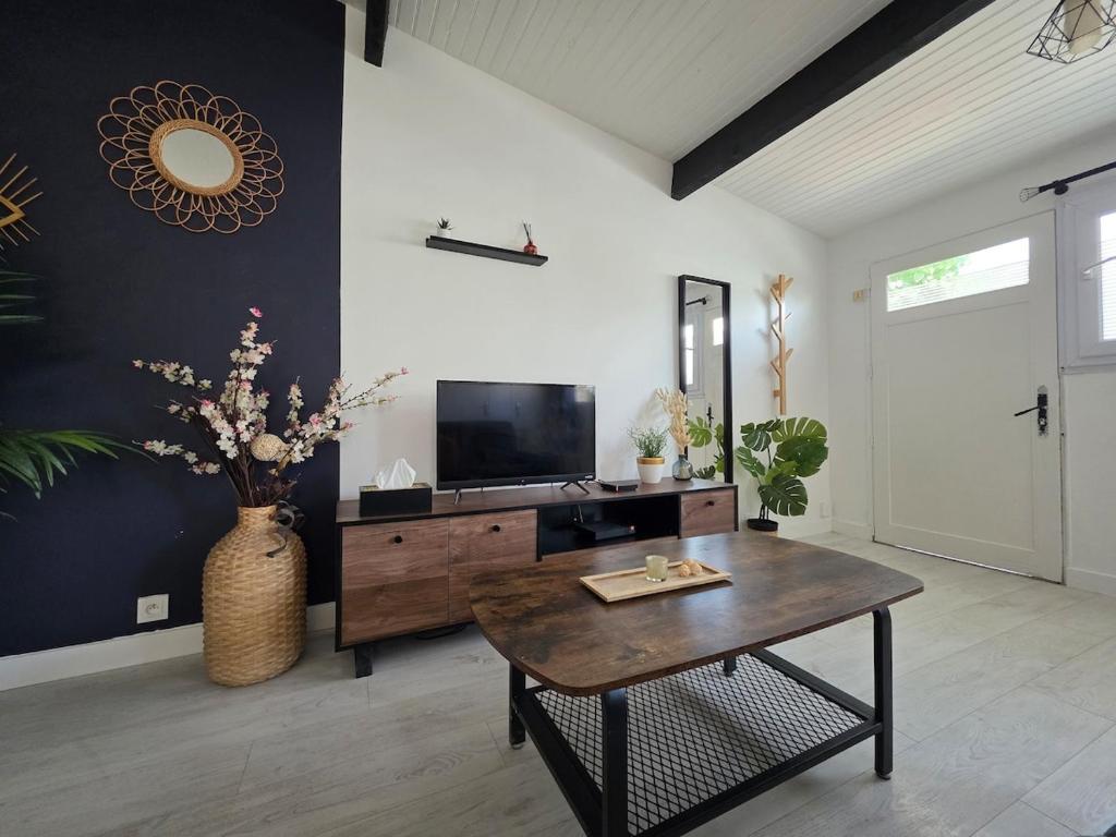 a living room with a table and a tv at Charming townhouse for 5 people in Pontault-Combault