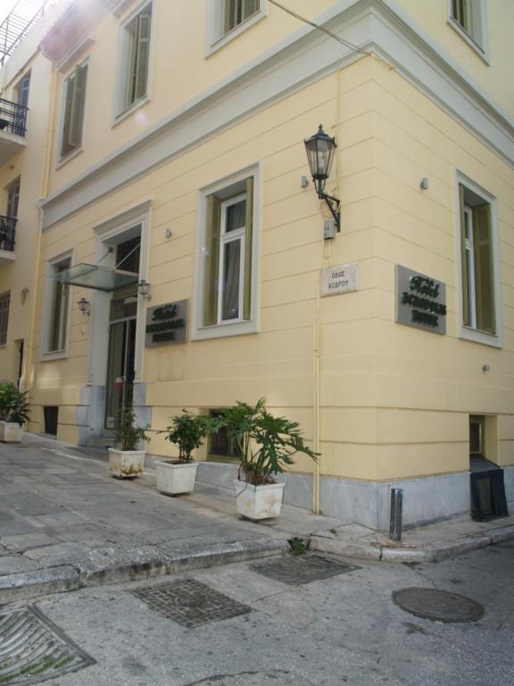 un edificio amarillo con macetas delante de él en Acropolis House, en Atenas
