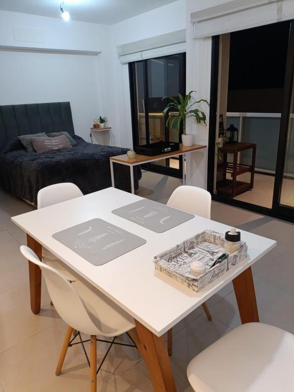 a white table and chairs in a room with a bed at Depto H in Buenos Aires