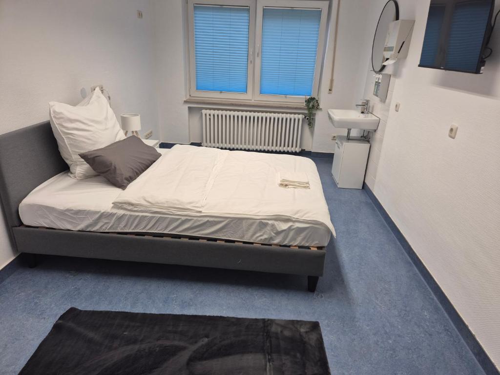 una habitación de hospital con una cama y un espejo en Möblierte Monteurzimmer in zentraler Lage in Büren, en Büren