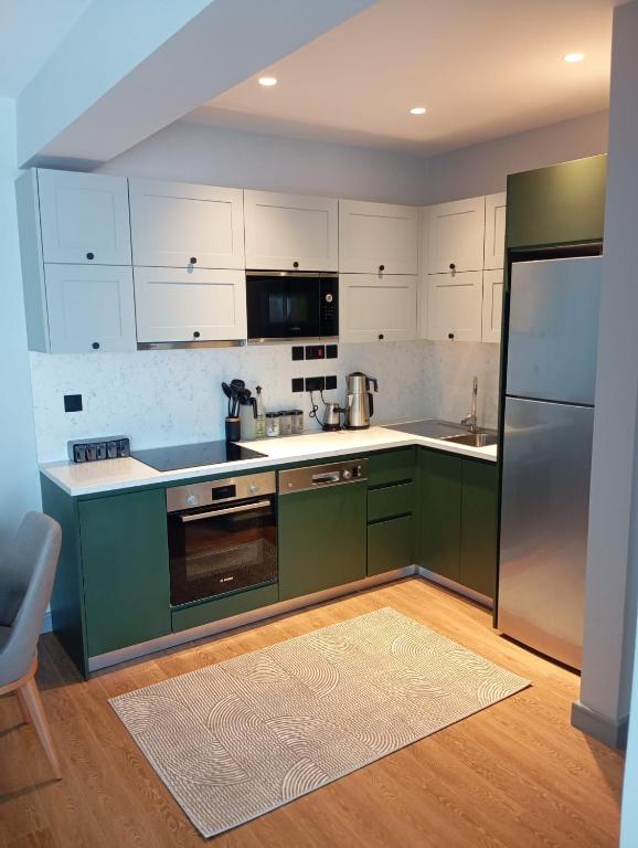 a kitchen with green cabinets and a stainless steel refrigerator at Exclusive Residence Famagusta in Famagusta