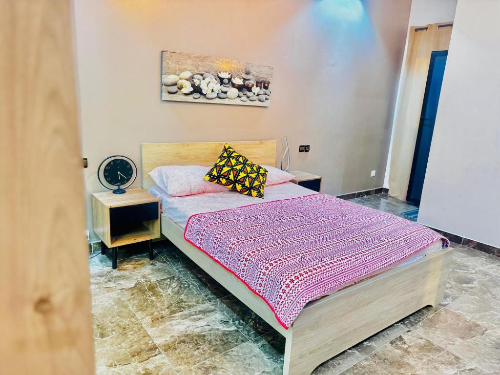 una camera con un letto e una coperta viola di Teranga SN a Dakar