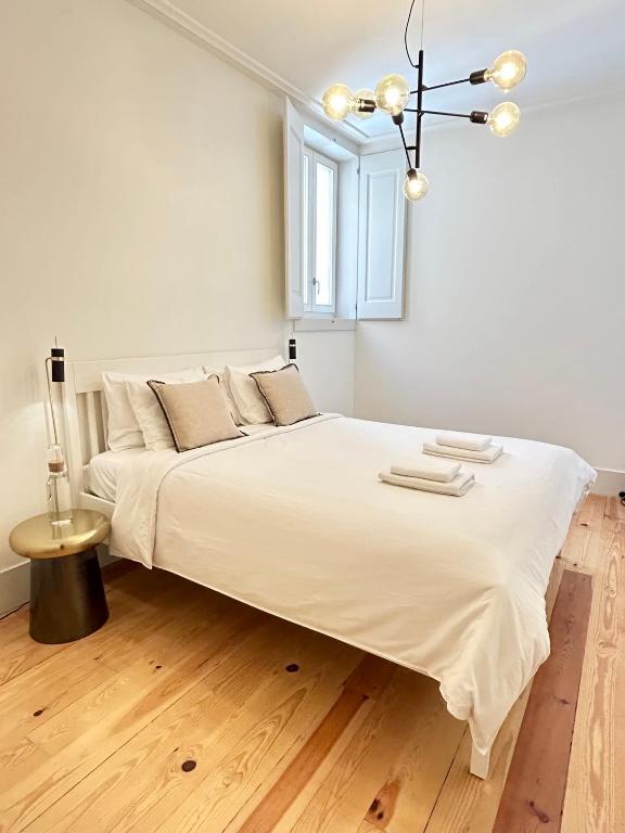 a large white bed in a room with a window at Santa Justa Cozy Room in Lisbon