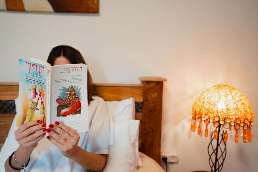 Eine Frau liest ein Buch in einem Hotelzimmer in der Unterkunft Unique Suite In Eilat in Eilat