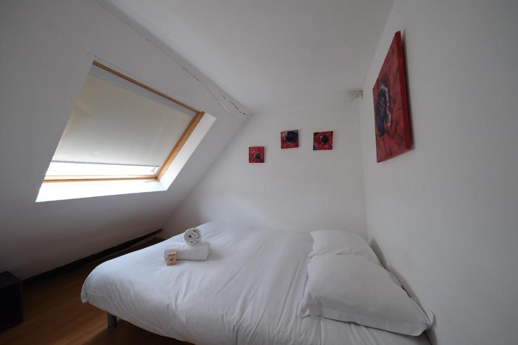 una camera da letto bianca con un letto e una finestra di Le Cocon Douillet a Rouen