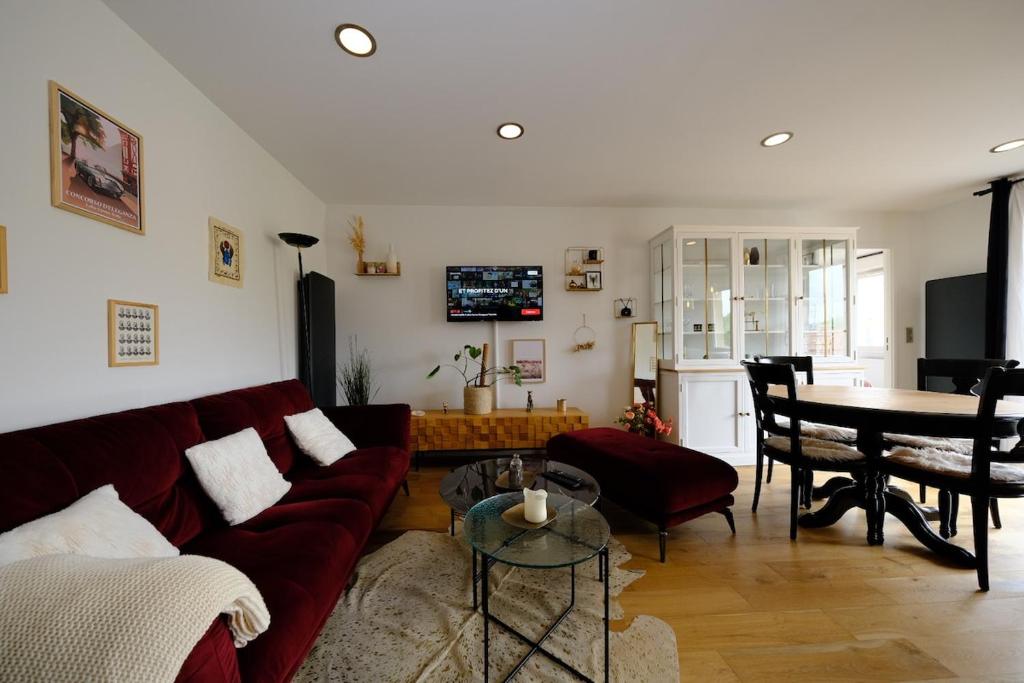een woonkamer met een rode bank en een tafel bij Rouen - Bienvenue chez Aurélie in Rouen