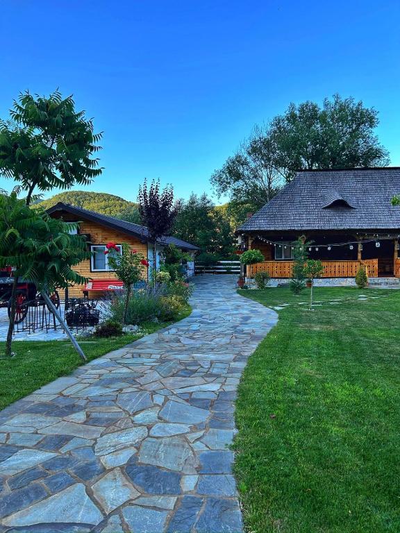 Gura VăiiOgrada Bunicului Seaca的房子前的一条石头小路