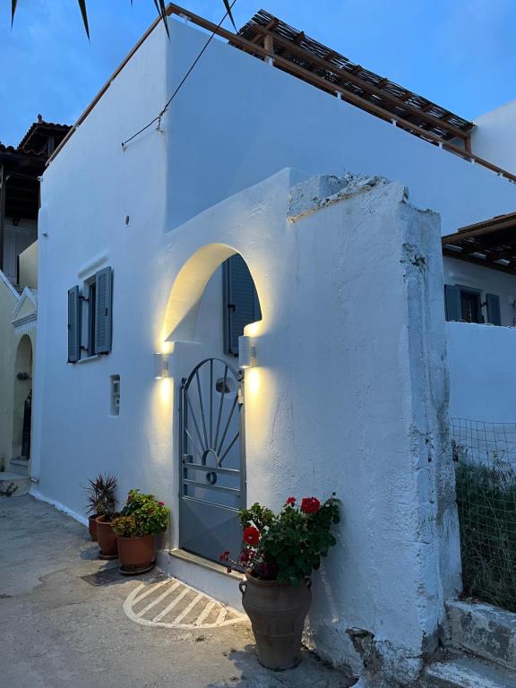 a white building with a door and some flowers at La Casa Bianca Naxos in Vívlos