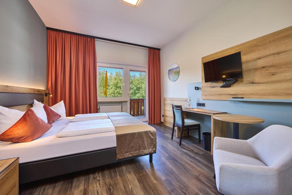 a hotel room with a bed and a desk at AURA-HOTEL Saulgrub in Saulgrub