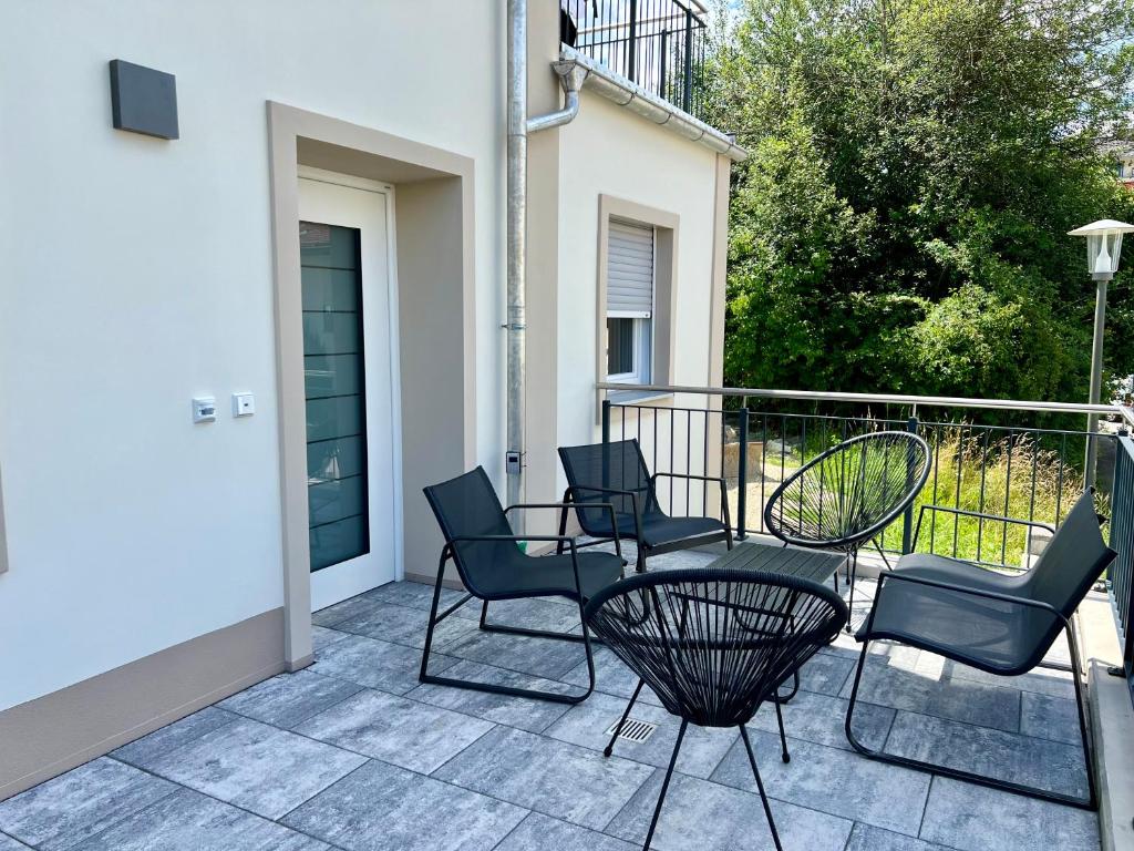 un patio avec des chaises et une table sur un balcon dans l'établissement Deluxe-Wohnung in Wasserburg Bahnhof - 94m2 - Smart TV - Terrasse - NEU, à Wasserburg am Inn