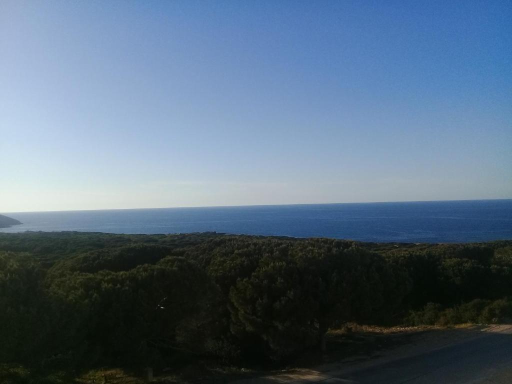 an overhead view of a road and the ocean at maison de charme au cœur du foret et plage de la grotte Bizerte in Banzart