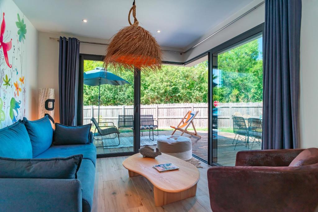 ein Wohnzimmer mit einem blauen Sofa und einem Tisch in der Unterkunft Happy Home - Charmante Maison Proche Plage in Saint-Gildas-de-Rhuys