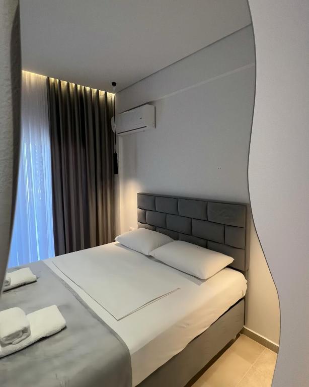 a bedroom with a large bed with a large window at Inscape Apartments in Sarandë