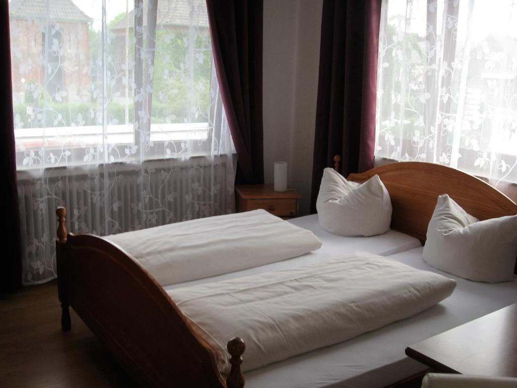 a bedroom with two beds and a large window at Hotel-Restaurant Cafe Caro in Carolinensiel