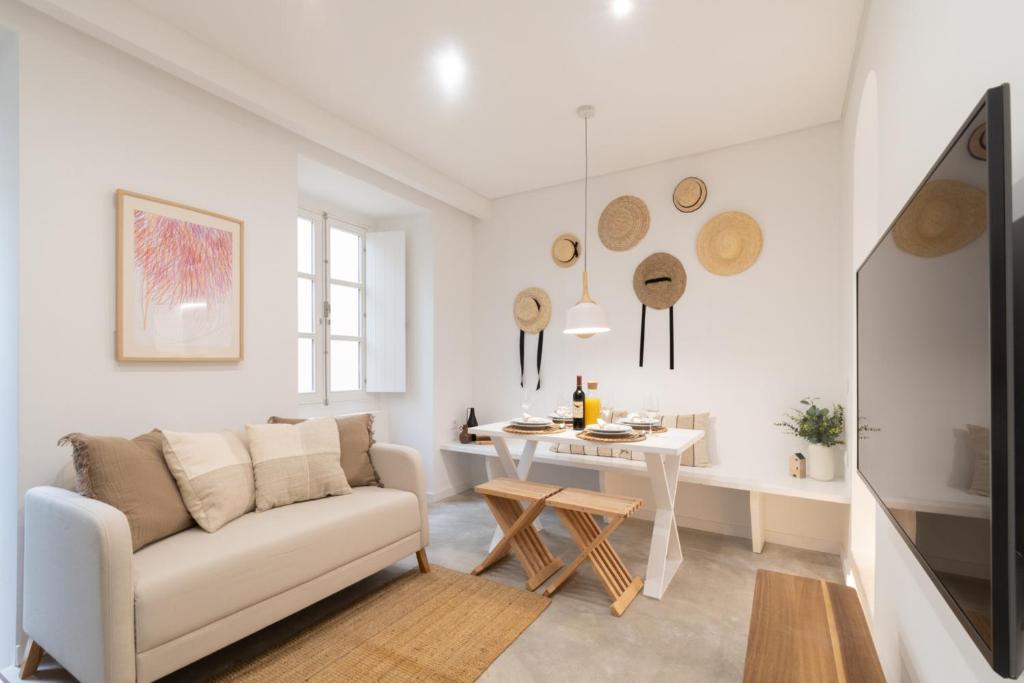 a white living room with a couch and a table at Casinha Amorosa in Faro