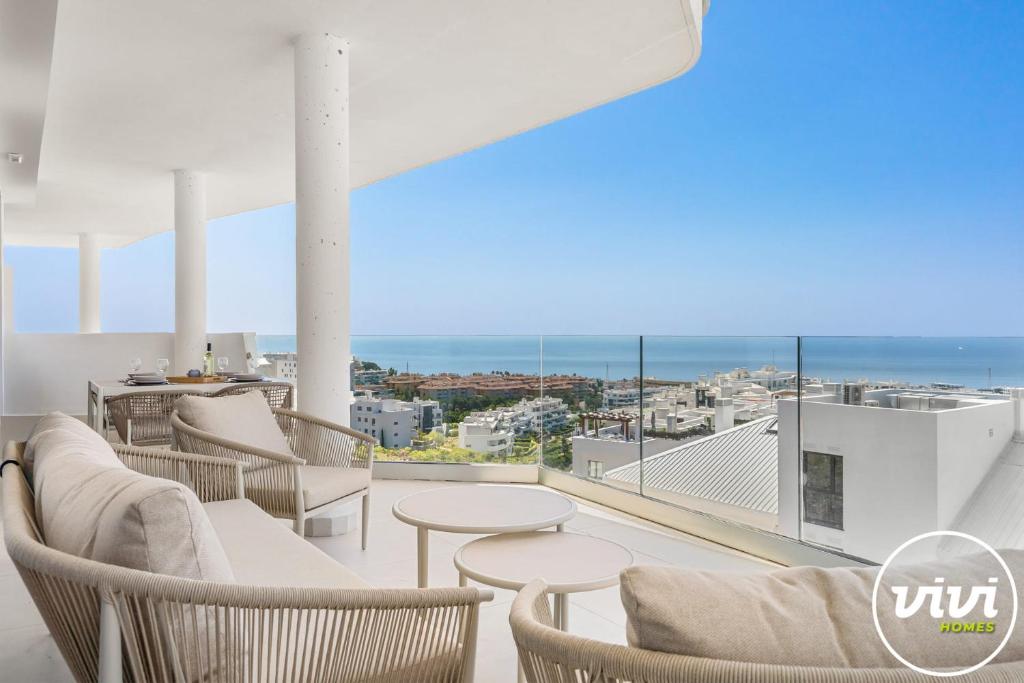 a balcony with chairs and tables and a view of the ocean at Mimosa in Fuengirola