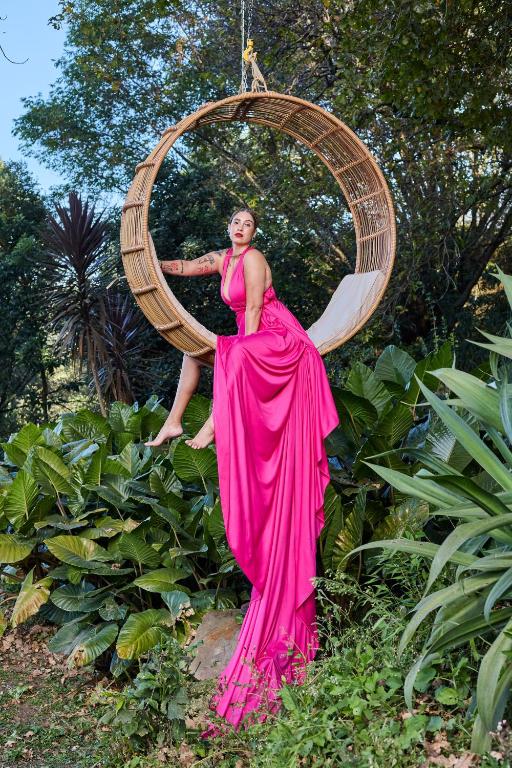a woman in a pink dress in front of a hoop at Pleasant Places By Sanaandi in Lidgetton