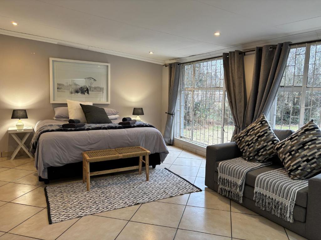 a bedroom with a bed and a couch at DullVino Wellington House in Dullstroom