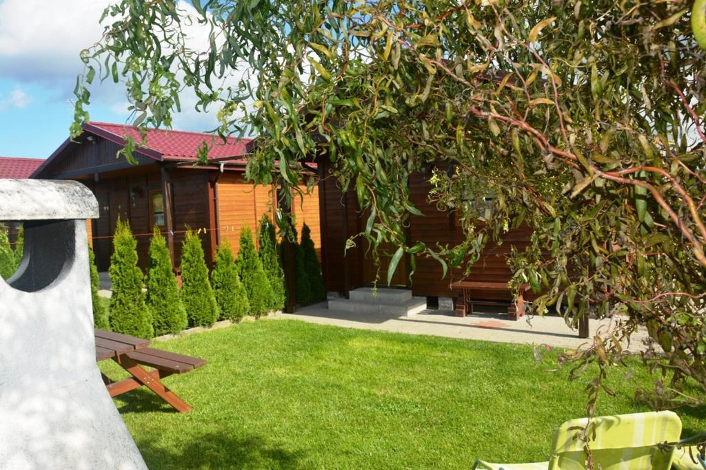 a house with a yard with a bench in front of it at Domki WIKA 2 in Ustka