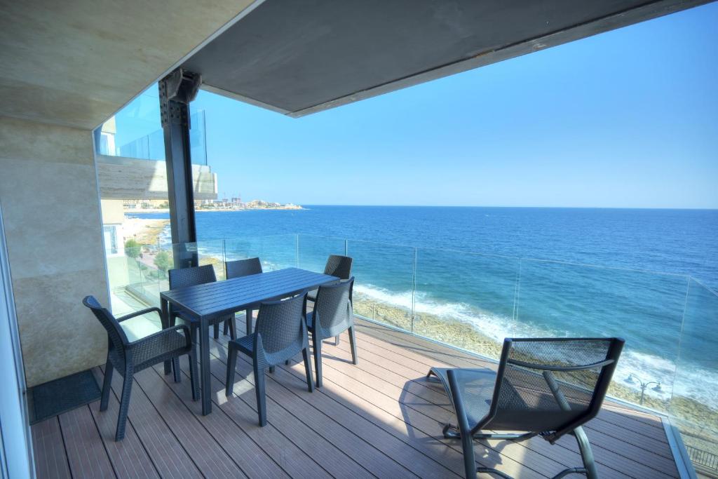 a balcony with a table and chairs and the ocean at Large 3 bedroom with seafront balcony DDIF1-5 in Sliema