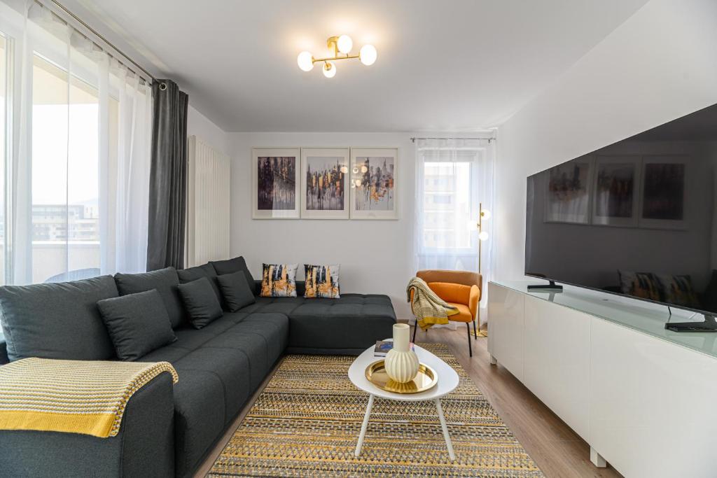 a living room with a couch and a tv at Mountain Views Urban Plaza in Braşov