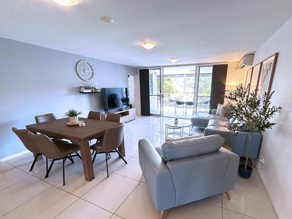 een woonkamer met een tafel en een eetkamer bij Bribie Sunset Vistas in Bongaree