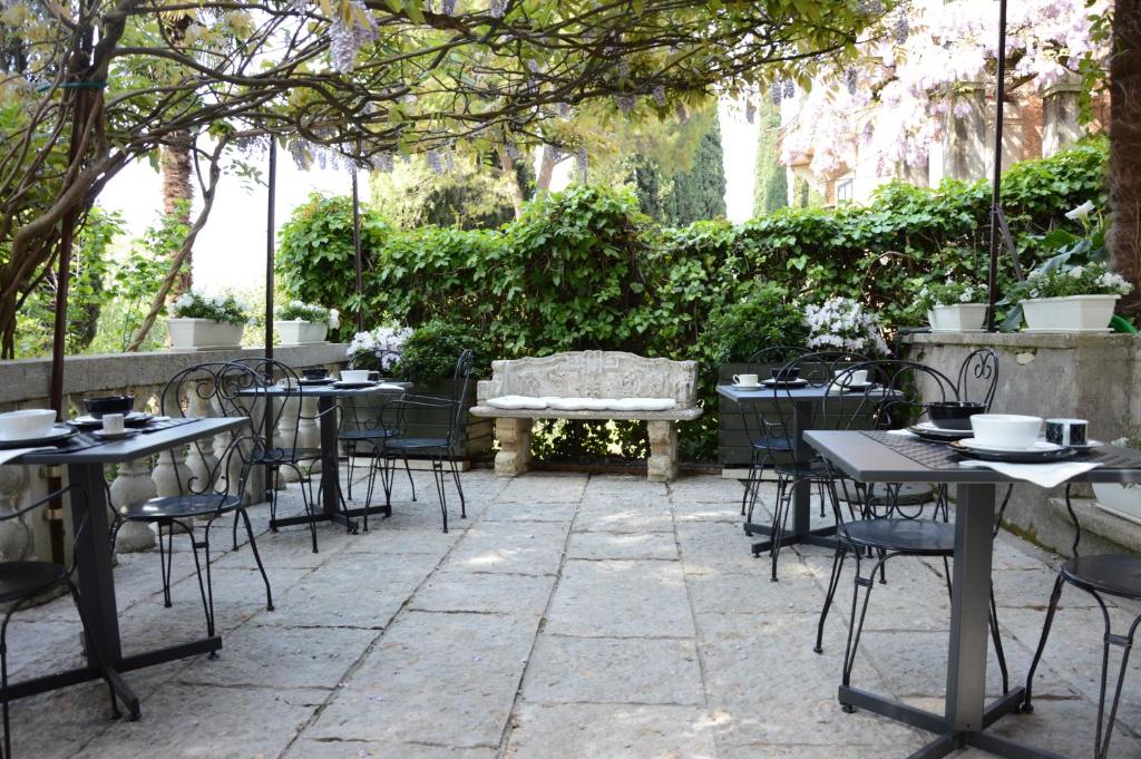 an outdoor patio with tables and chairs and a bench at Residenza Ca' degli Enzi in Verona