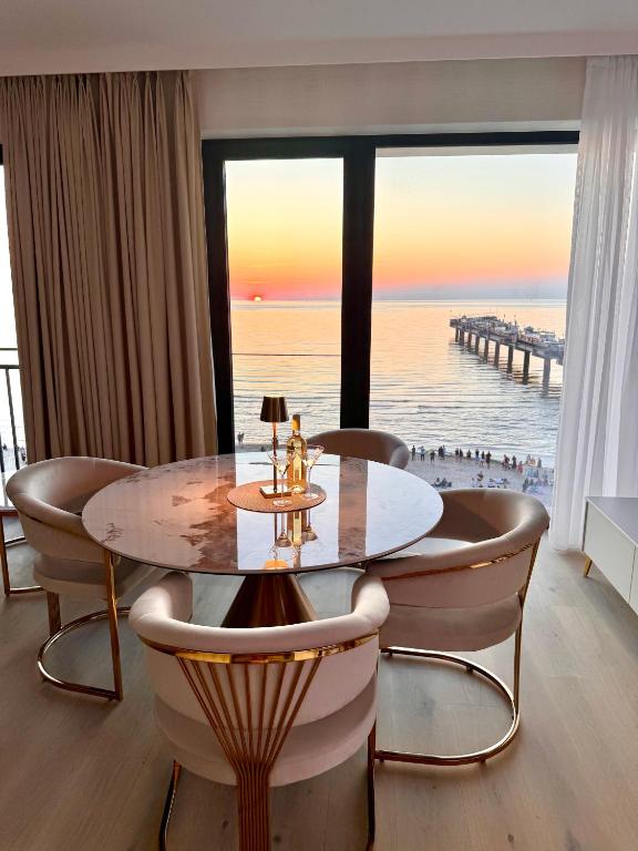 米兹多洛杰Baltic Infinity Resort&Spa Apartament Dworek的一间带桌子并可欣赏海景的餐厅