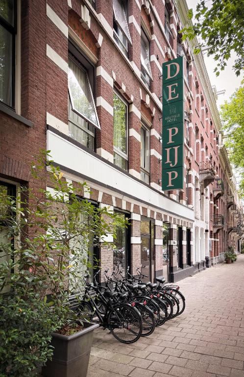 a row of bikes parked outside of a building at De Pijp Hotel in Amsterdam