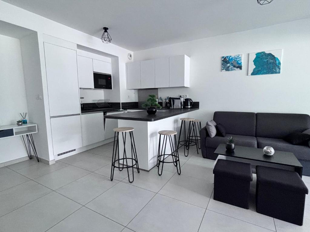 un salon avec un canapé et une cuisine dans l'établissement T2 à proximité des plages, à Saint-Cyr-sur-Mer