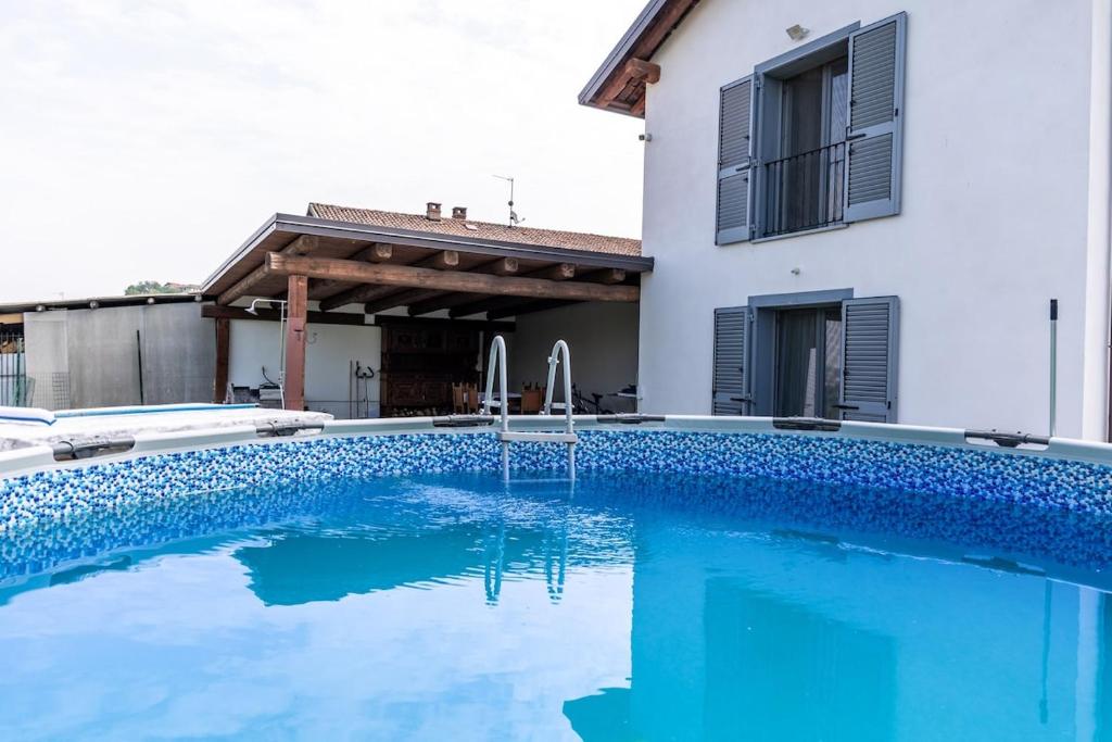a swimming pool in front of a house at Villa Katalea - piscina privata e barbecue in Asti