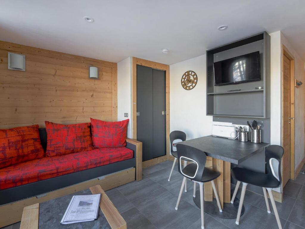 un salon avec un canapé rouge et une table dans l'établissement Studio rénové avec parking gratuit et animaux admis - FR-1-181-2086, à La Plagne Tarentaise