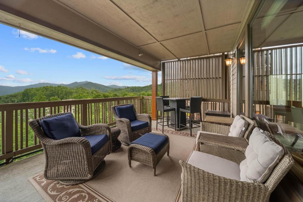 a balcony with chairs and a table and a piano at Endless Grandfather View at Echota in Valle Crucis