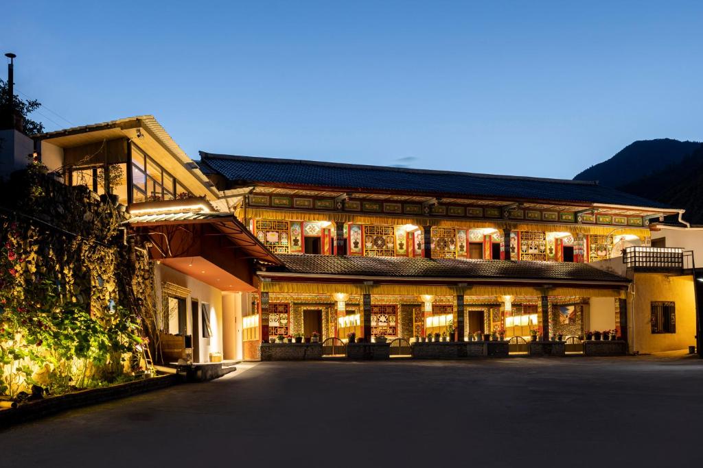 un edificio illuminato di notte di Jiuzhaigou Jijian Nanshan B&B a Valle del Jiuzhaigou