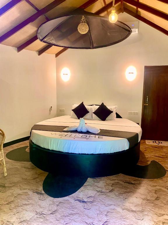 a bed in a room with a large beditures at Ritter Kreuz Cabana Resort in Tangalle