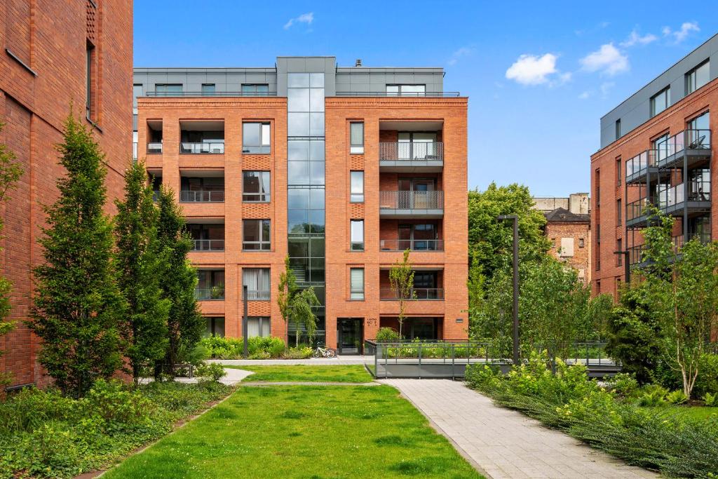 an apartment building with a garden in front of it at Scala Apartments by Blue Mandarin in Gdańsk