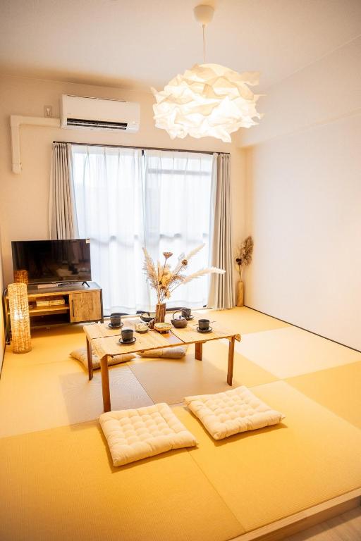 Una sala de estar con una mesa y un televisor. en Wa Wonomiya 606Nagoya Station Walking Distance Maximum 4 People Separate Washbasin BathroomToilet Japanese Style Modern Design With Dryer, en Nagoya